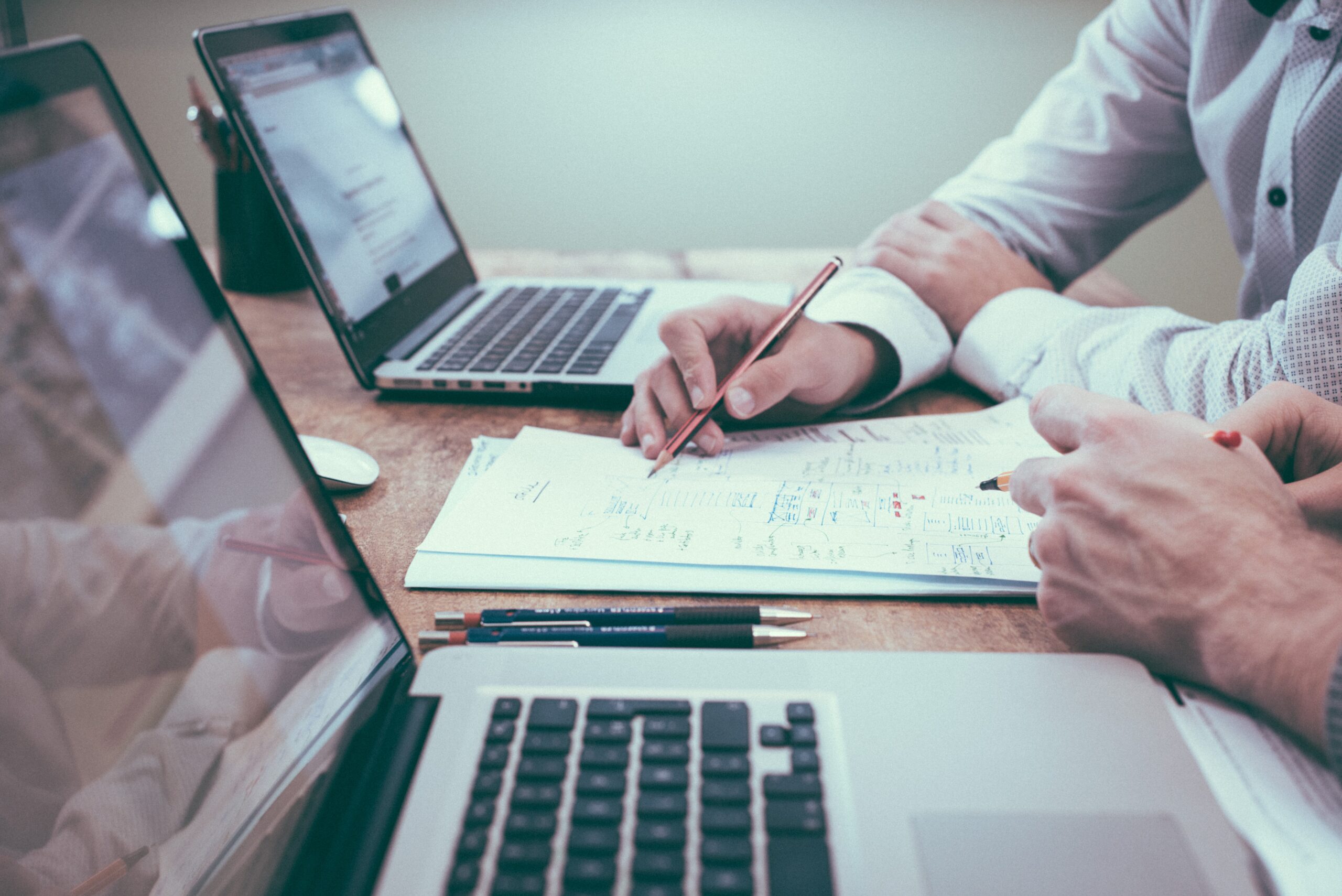 two people looking over a business loan document in front of laptops